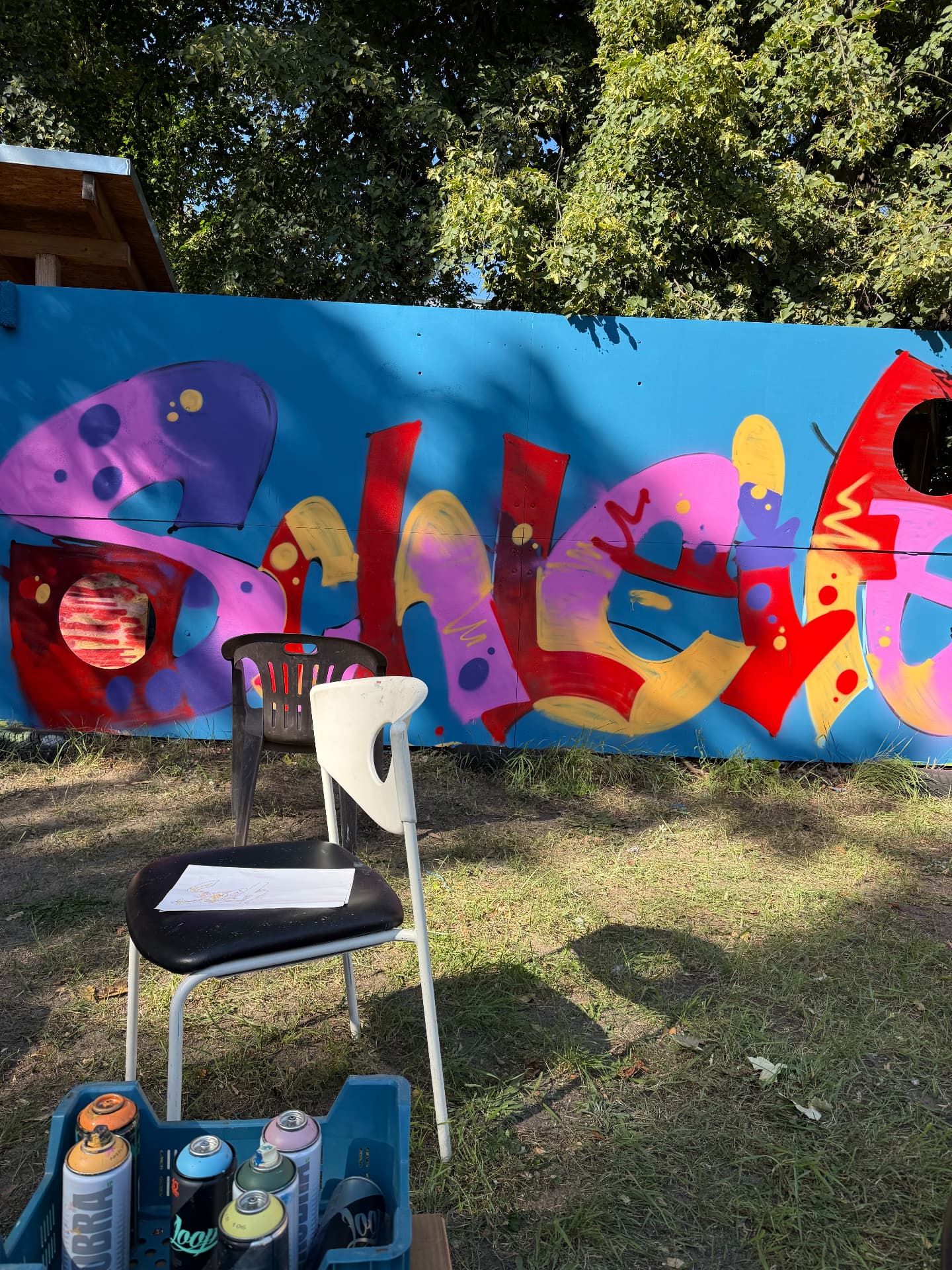 Fertig gesprühter, bunter Graffiti-Schriftzug auf einer Wand im Freien