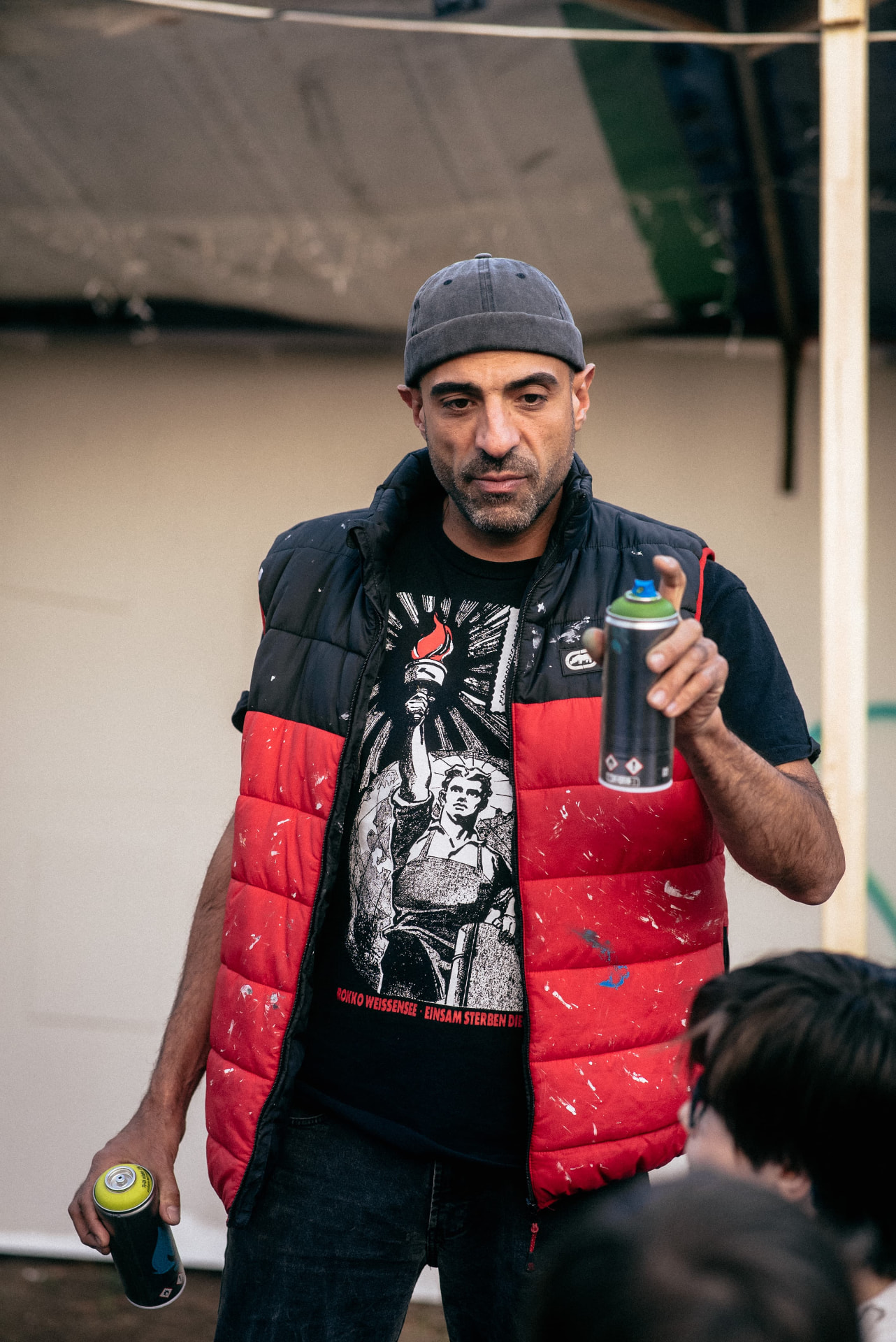 Baris Caniperk von WALLSTORIES mit Sprühdosen während eines Graffiti-Workshops