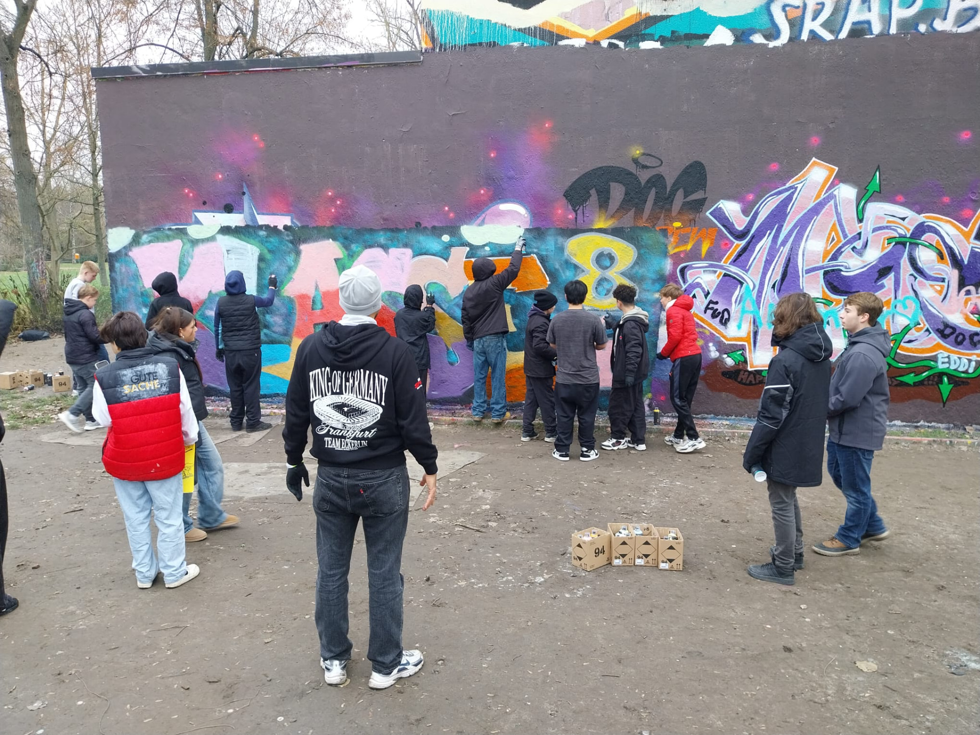 Jugendliche gestalten gemeinsam eine große Wand