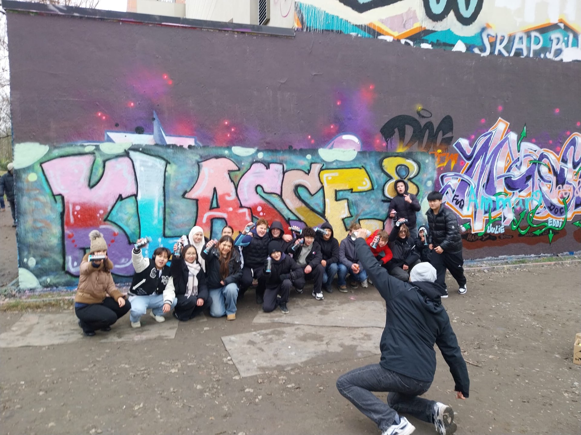 Schulklasse vor dem fertigen Mural „KLASSE 8“