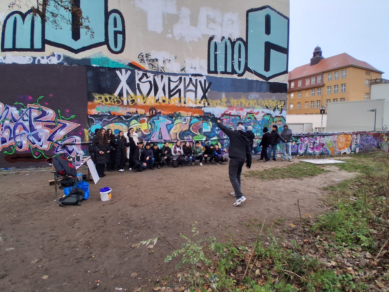 Große Gruppe vor einer gemeinsam gestalteten Graffitiwand