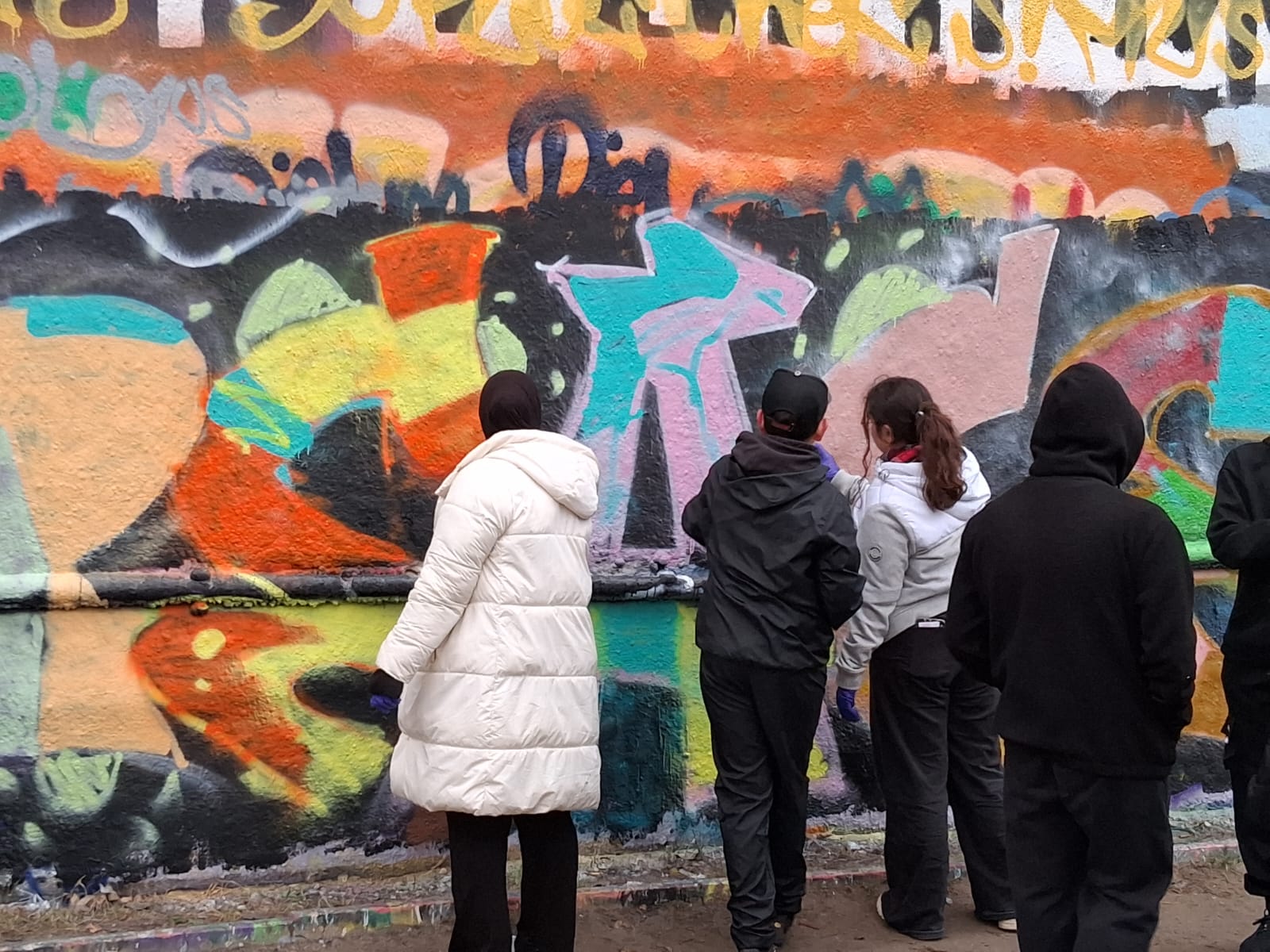 Jugendliche gestalten gemeinsam ein großformatiges Mural