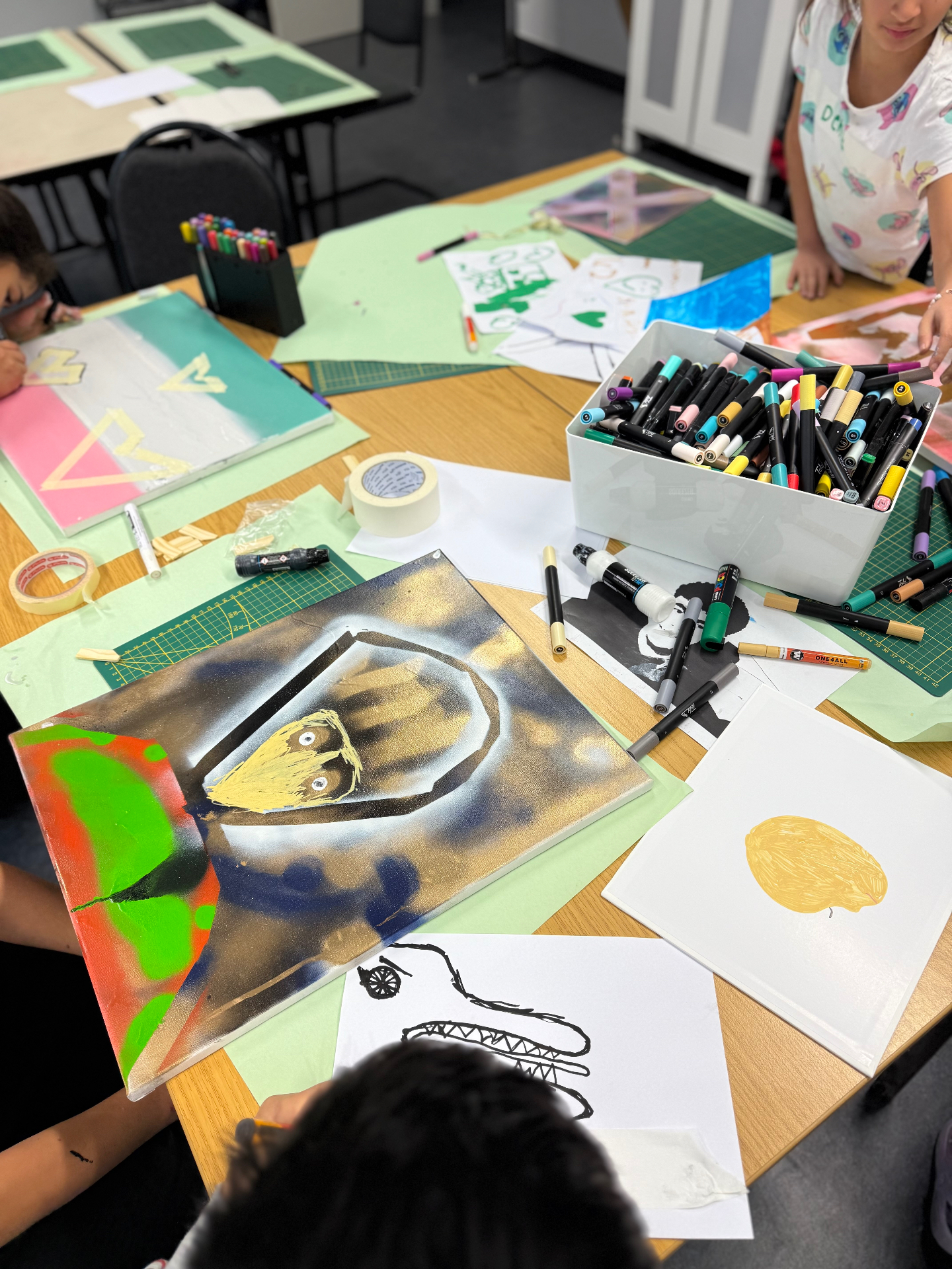 Stencils, Farben und Marker auf dem Arbeitstisch eines Indoor-Workshops